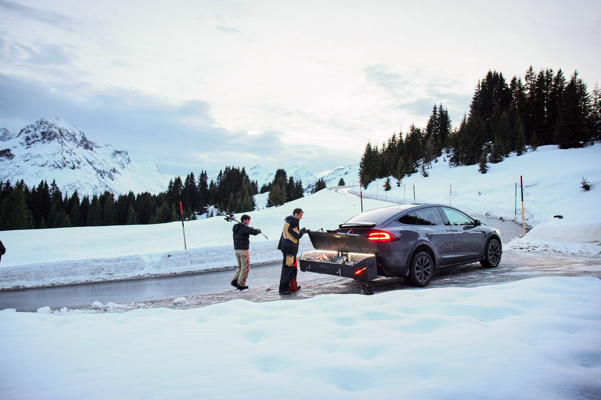Auto met een IXTAbox op de trekhaak in een besneeuwd berglandschap